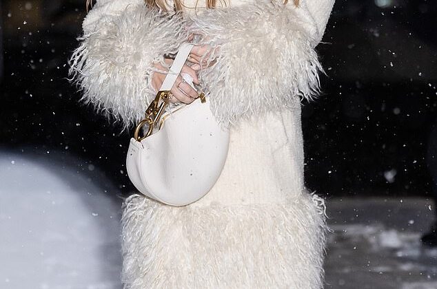 Sydney Sweeney the snow queen models stylish ivory coat as she playfully chucks snowballs in frigid NYC